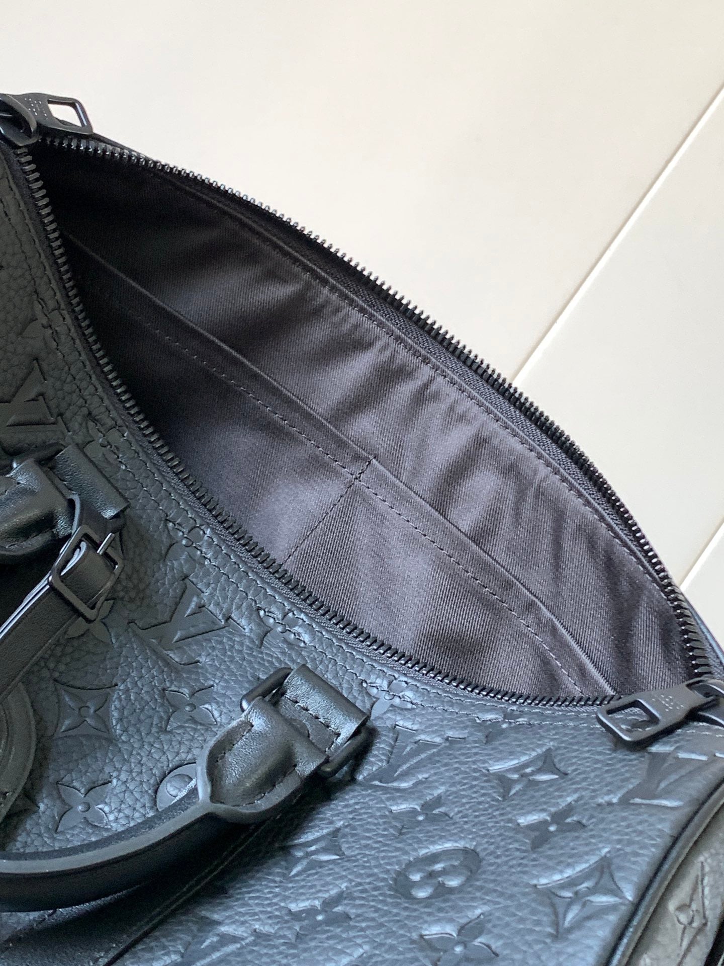 Dark monogram zip pocket interior with fabric lining and zipper track detail