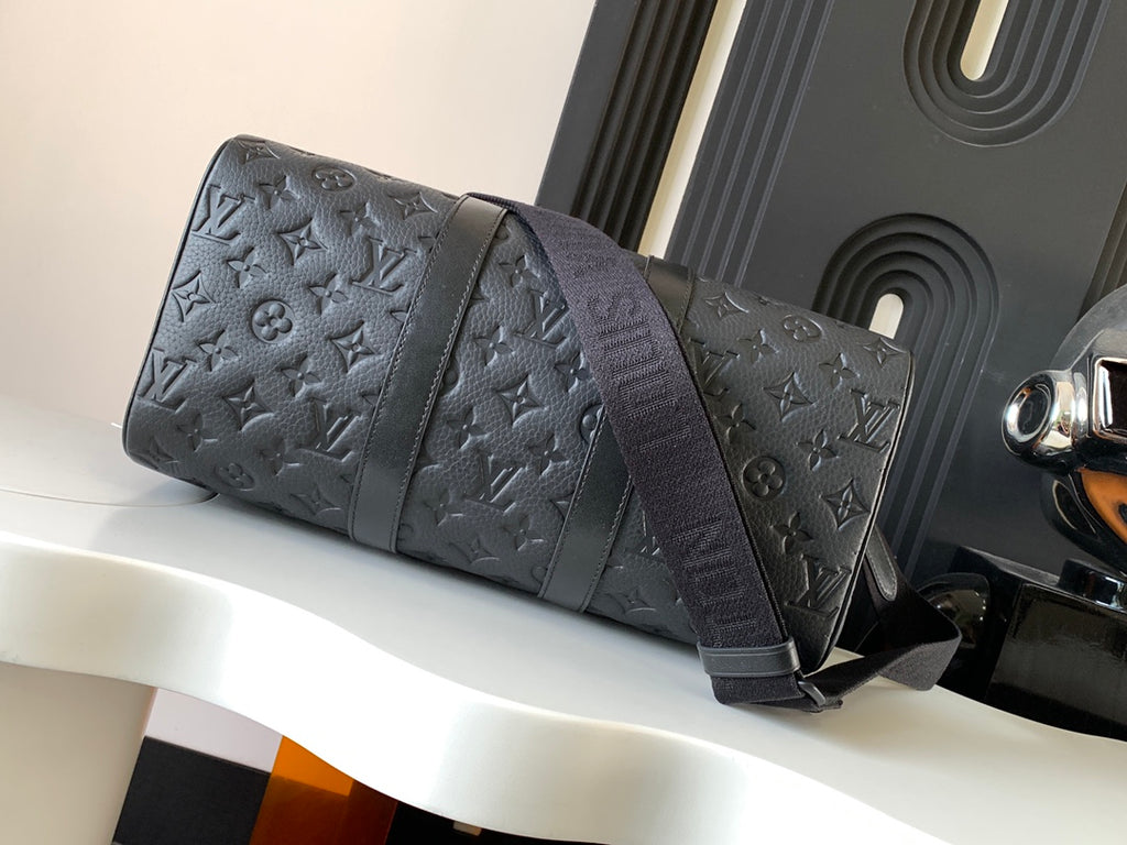 Dark monogram duffel bag with long shoulder strap and rounded shape
