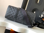 Dark monogram duffel bag with long shoulder strap and rounded shape