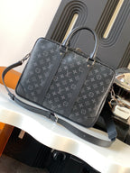 Handbag front in dark monogram canvas with top handles and adjustable shoulder strap