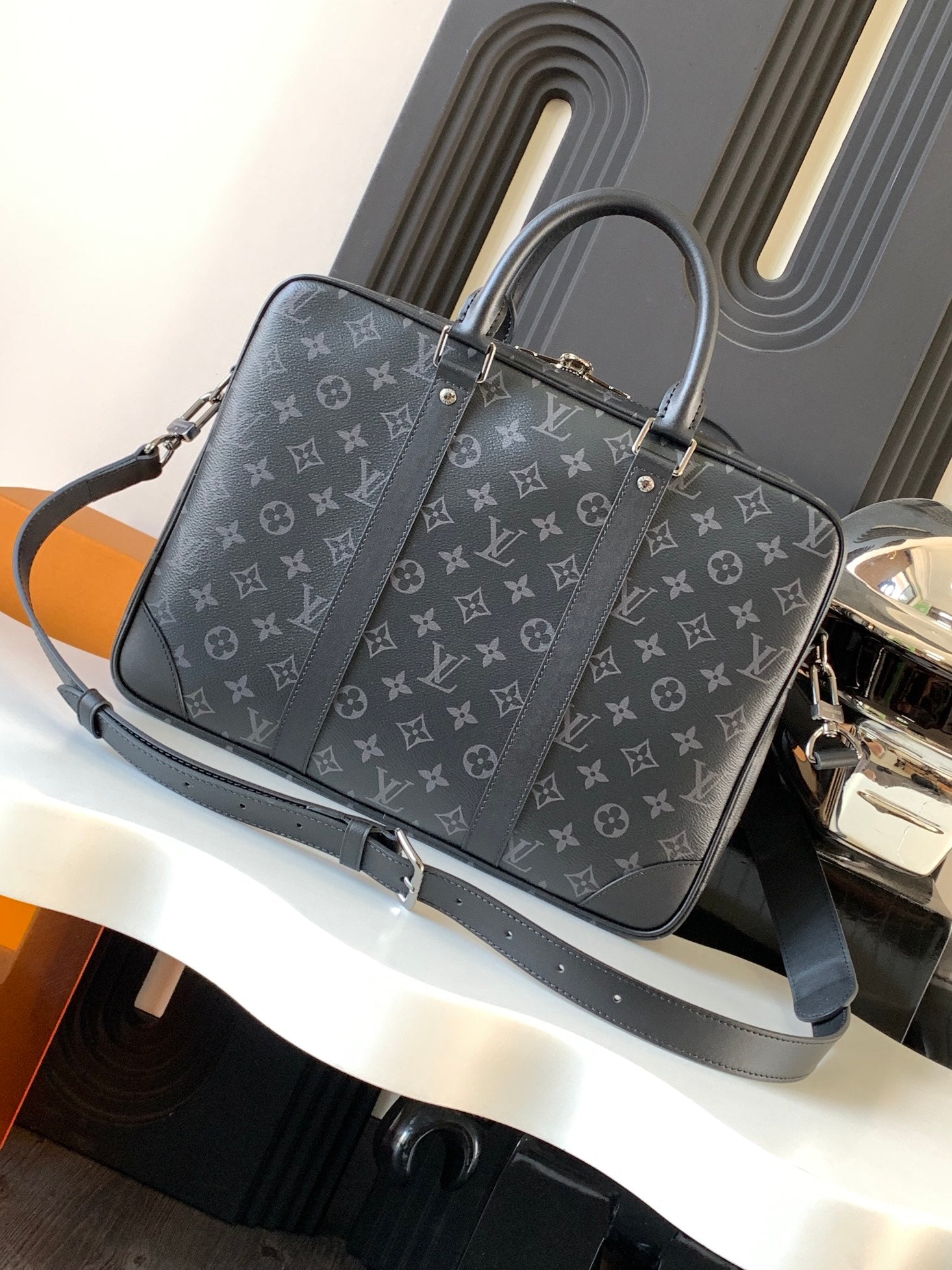 Handbag front in dark monogram canvas with top handles and adjustable shoulder strap