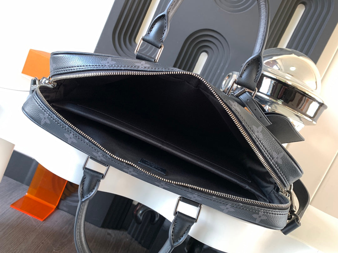 Handbag open top with black interior, dark monogram trim, and zipper closure