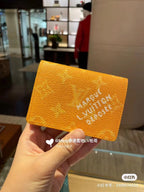 Louis Vuitton small wallet, bright orange textured monogram print with logo on flap