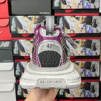 Grey and purple sneakers heel view with size tag showing “42”