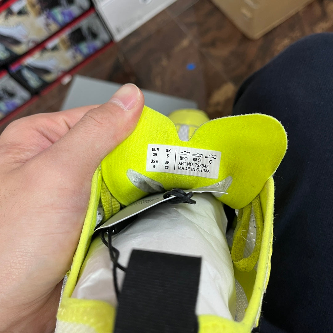 Neon yellow shoe interior with size label and black hang tag