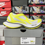 Neon yellow and white lace-up running shoe on a box