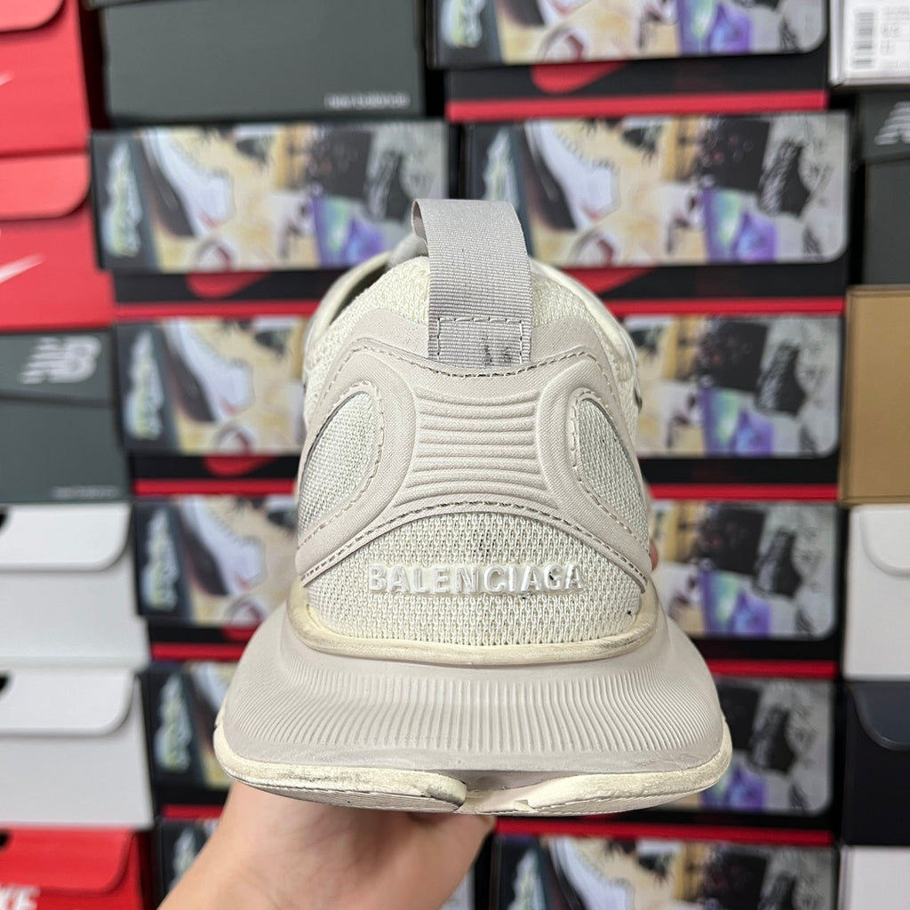 Cream sneaker back view with strap pull tab and Balenciaga logo on heel