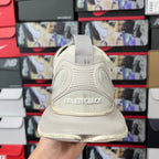 Cream sneaker back view with strap pull tab and Balenciaga logo on heel