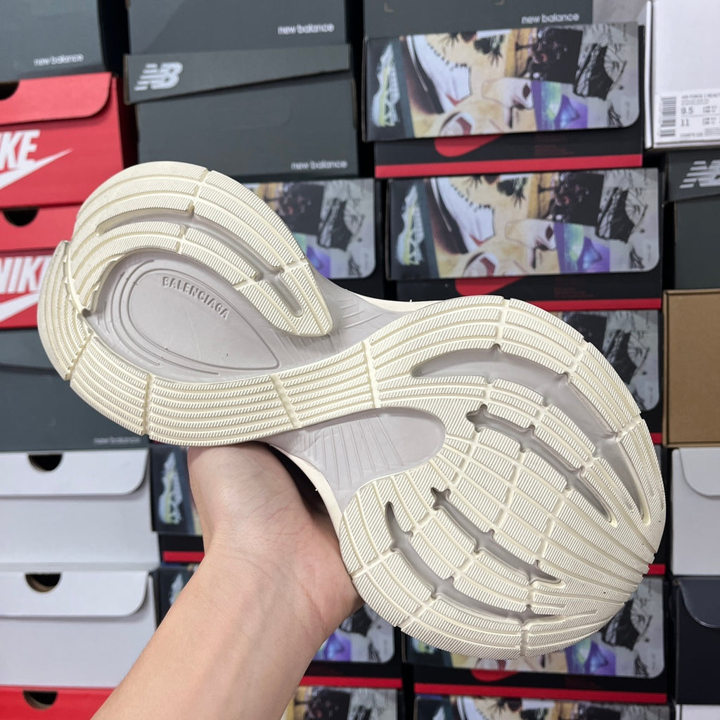 Cream sneaker outsole view with textured traction tread and raised grooves