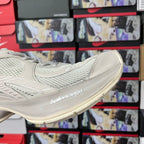 Cream sneaker side view with stitched overlays and Balenciaga logo on sole