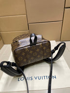 Monogram mini duffel-style bag with black strap and handles, dark brown canvas exterior
