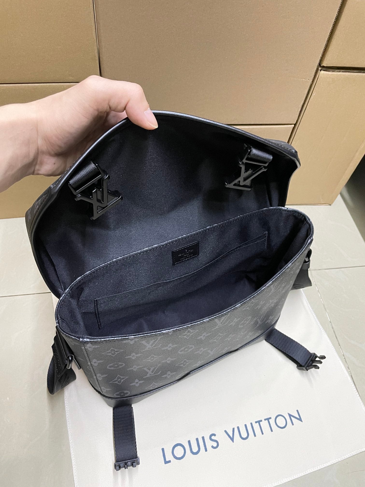 Men’s monogram crossbody bag open top view showing interior pocket and strap