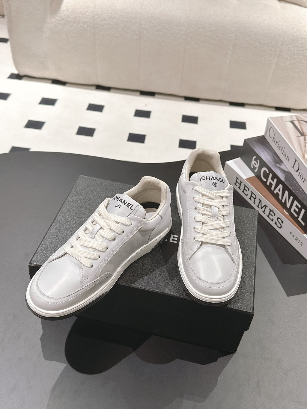 White leather low-top sneaker pair with lace-up design, side logos visible