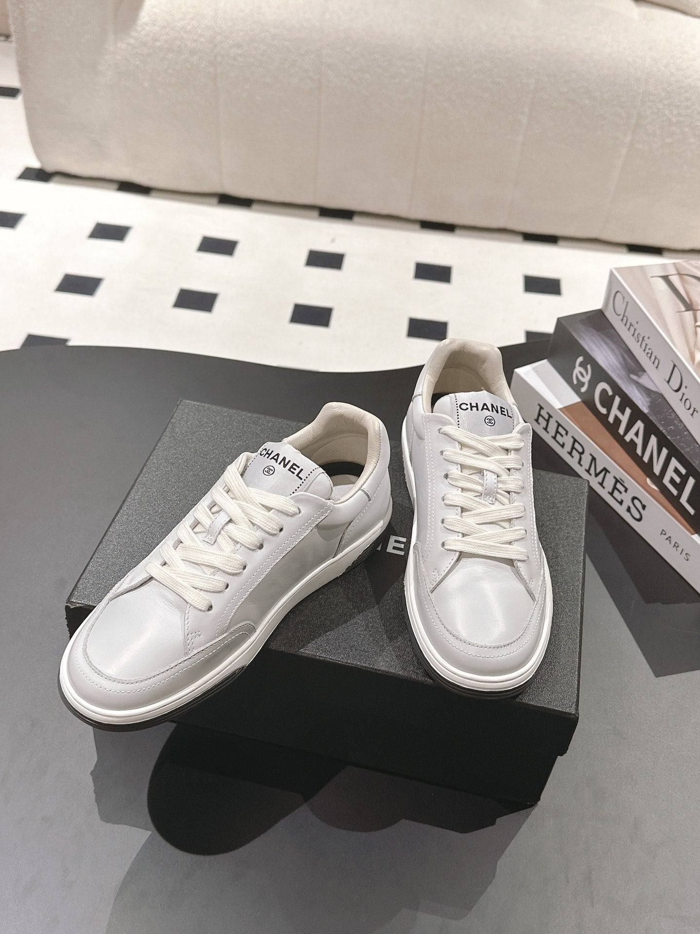 White leather low-top sneaker pair with lace-up design, side logos visible