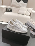 White leather low-top sneaker with lace-up front and Chanel side logo