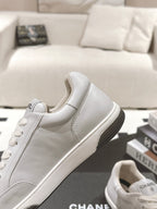 White leather low-top sneaker side profile with lace-up front and dark sole