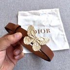 Dior brown leather belt with gold butterfly buckle, held in hand for detail.