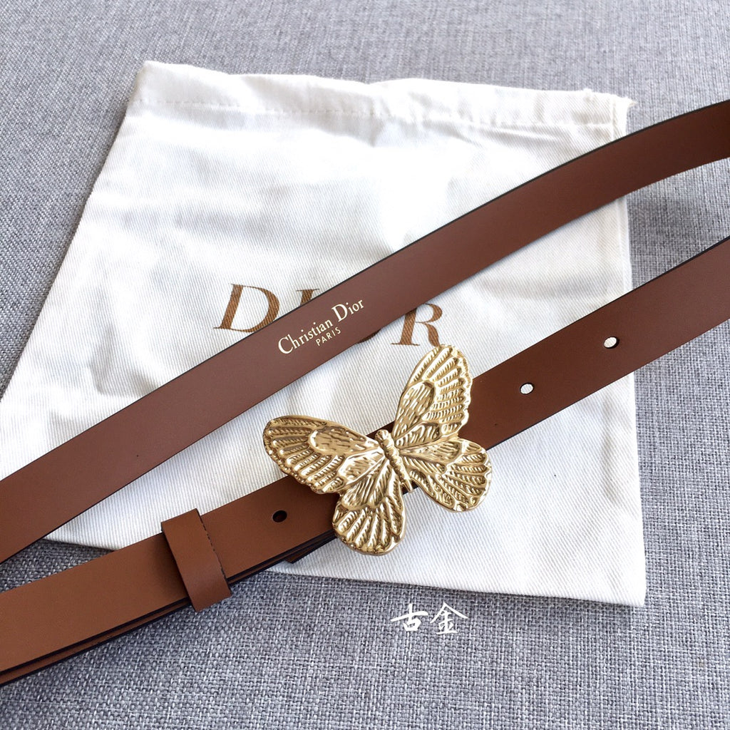 Dior belt with brown leather strap and gold butterfly buckle on a flat lay.