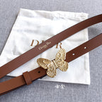 Dior belt with brown leather strap and gold butterfly buckle on a flat lay.