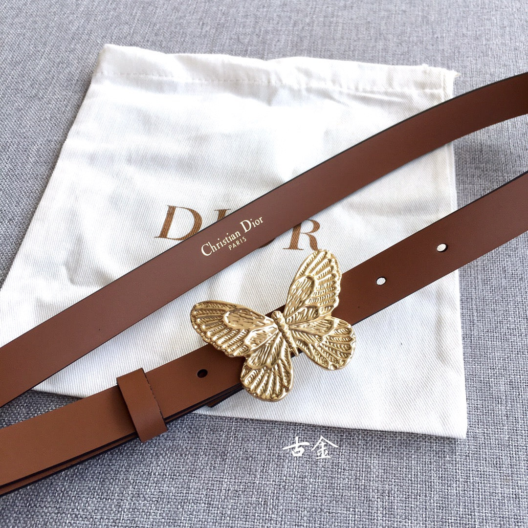 Dior belt with brown leather strap and gold butterfly buckle on a flat lay.