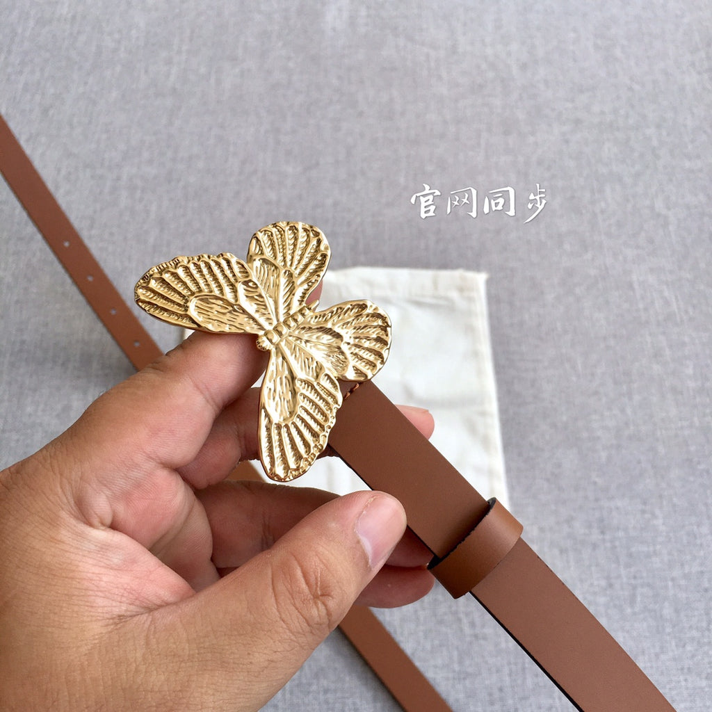 Dior brown belt close-up: gold butterfly buckle mounted on the leather strap.