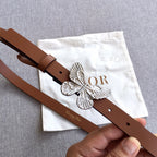 Brown leather belt with silver butterfly buckle and adjustable strap holes