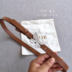Brown leather belt with silver butterfly buckle and adjustable strap holes