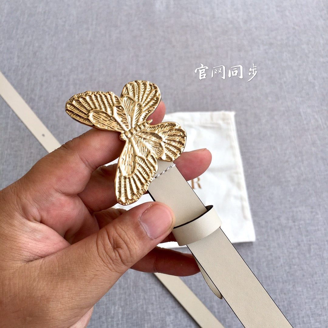 Light beige belt with gold butterfly buckle close-up, showing stud hole strap end