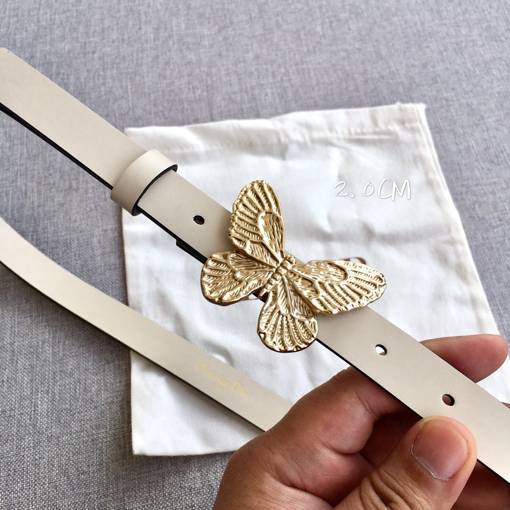 Light beige belt close-up with gold butterfly buckle, pin closure and eyelet holes