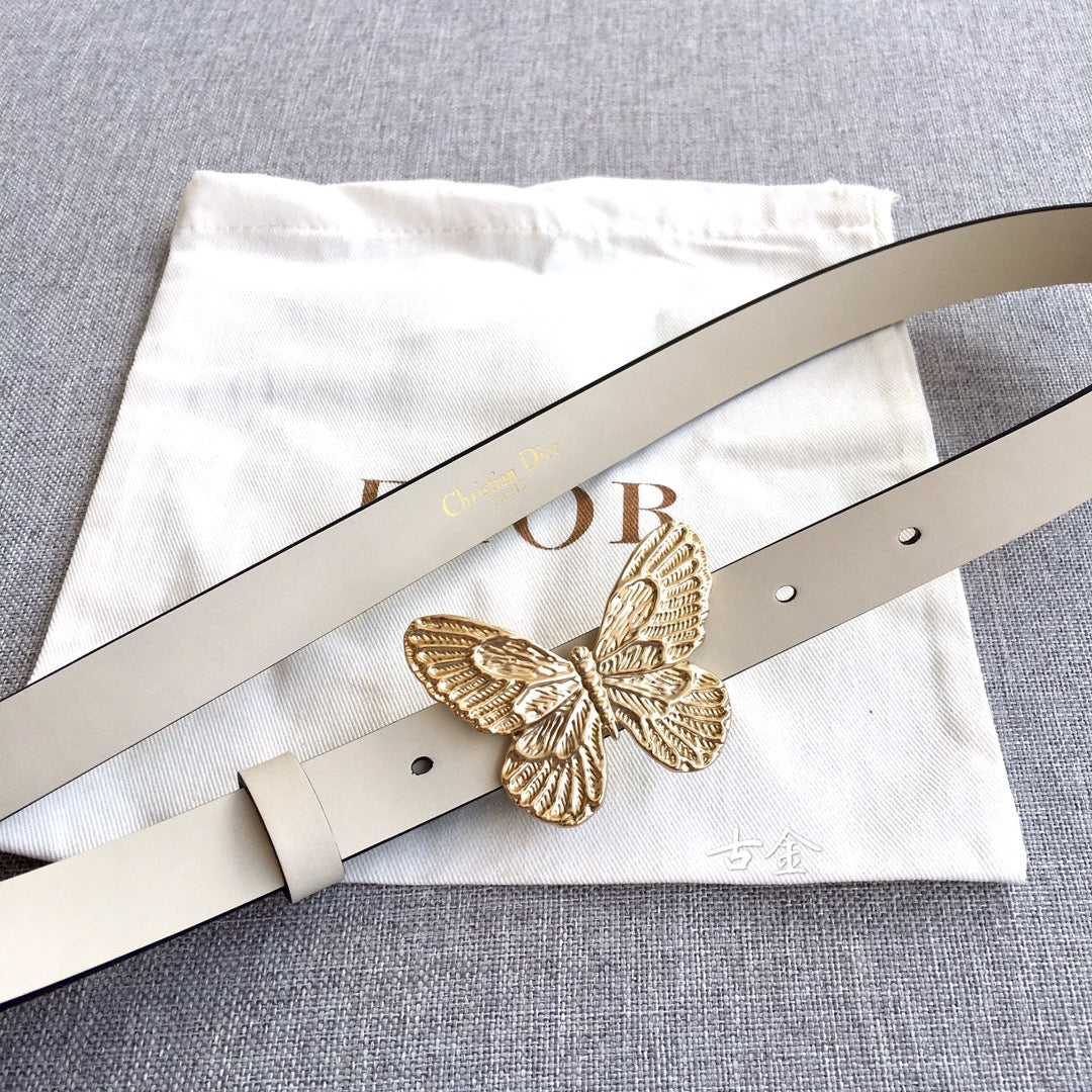 Light beige belt with gold butterfly buckle and stud holes, laid on a cloth pouch
