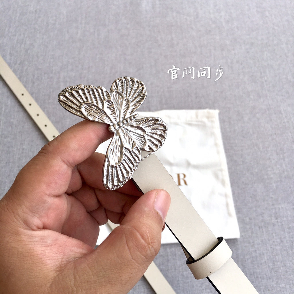 Cream leather belt with large silver butterfly buckle and punched holes
