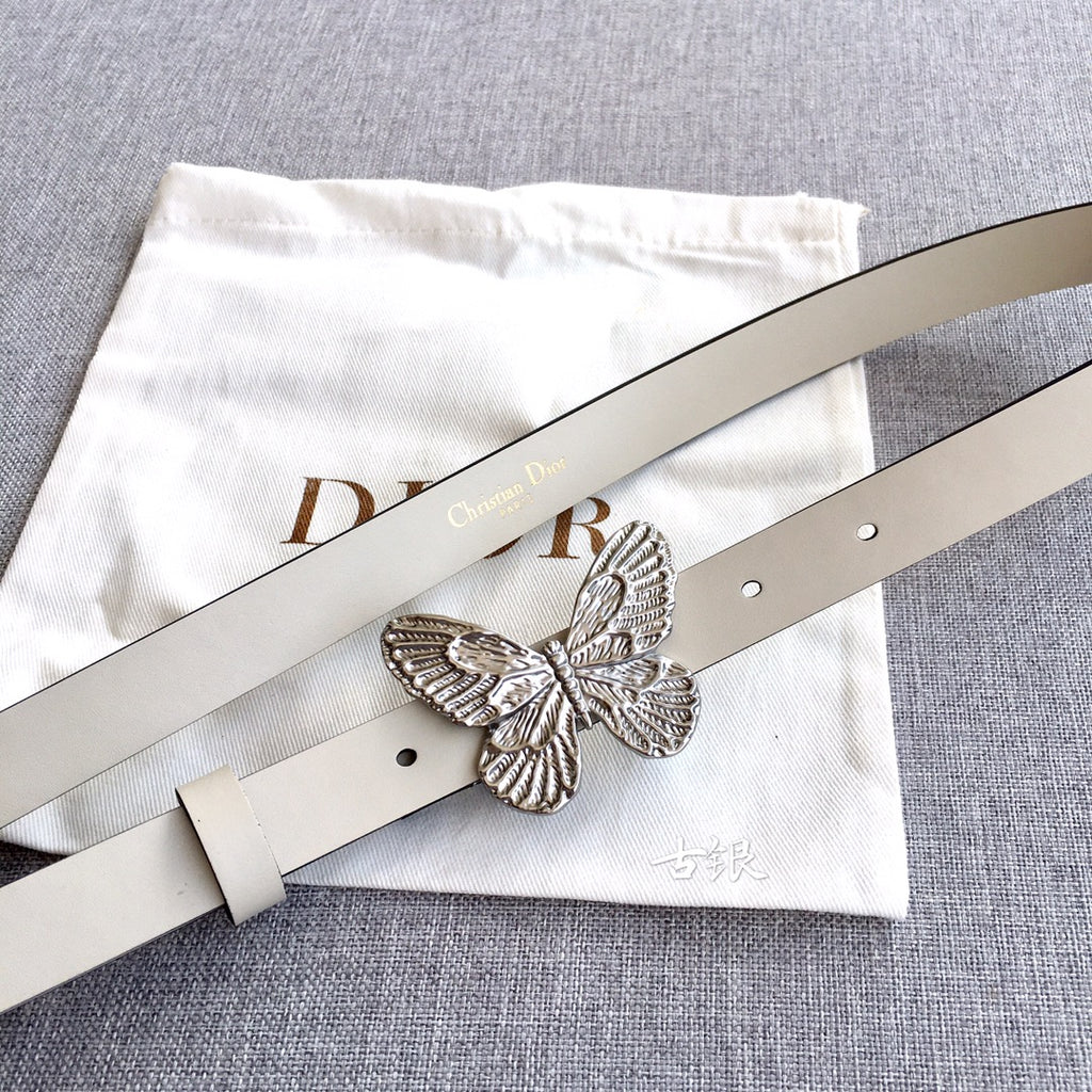 Cream leather belt with silver butterfly buckle and punched holes, top view