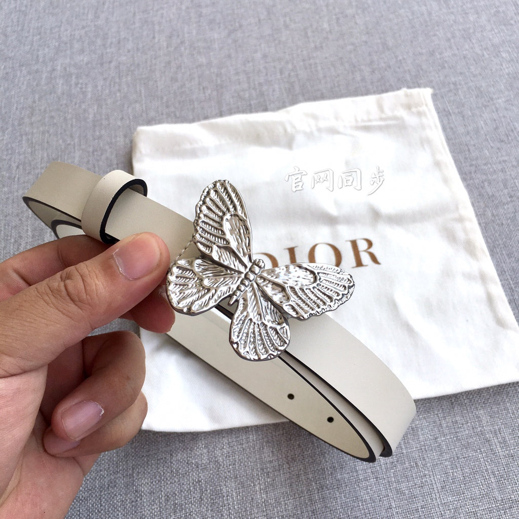 Cream leather belt with silver butterfly buckle and punched holes, hand holding end