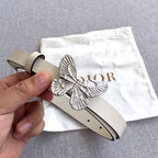 Cream leather belt with silver butterfly buckle and punched holes, hand holding end
