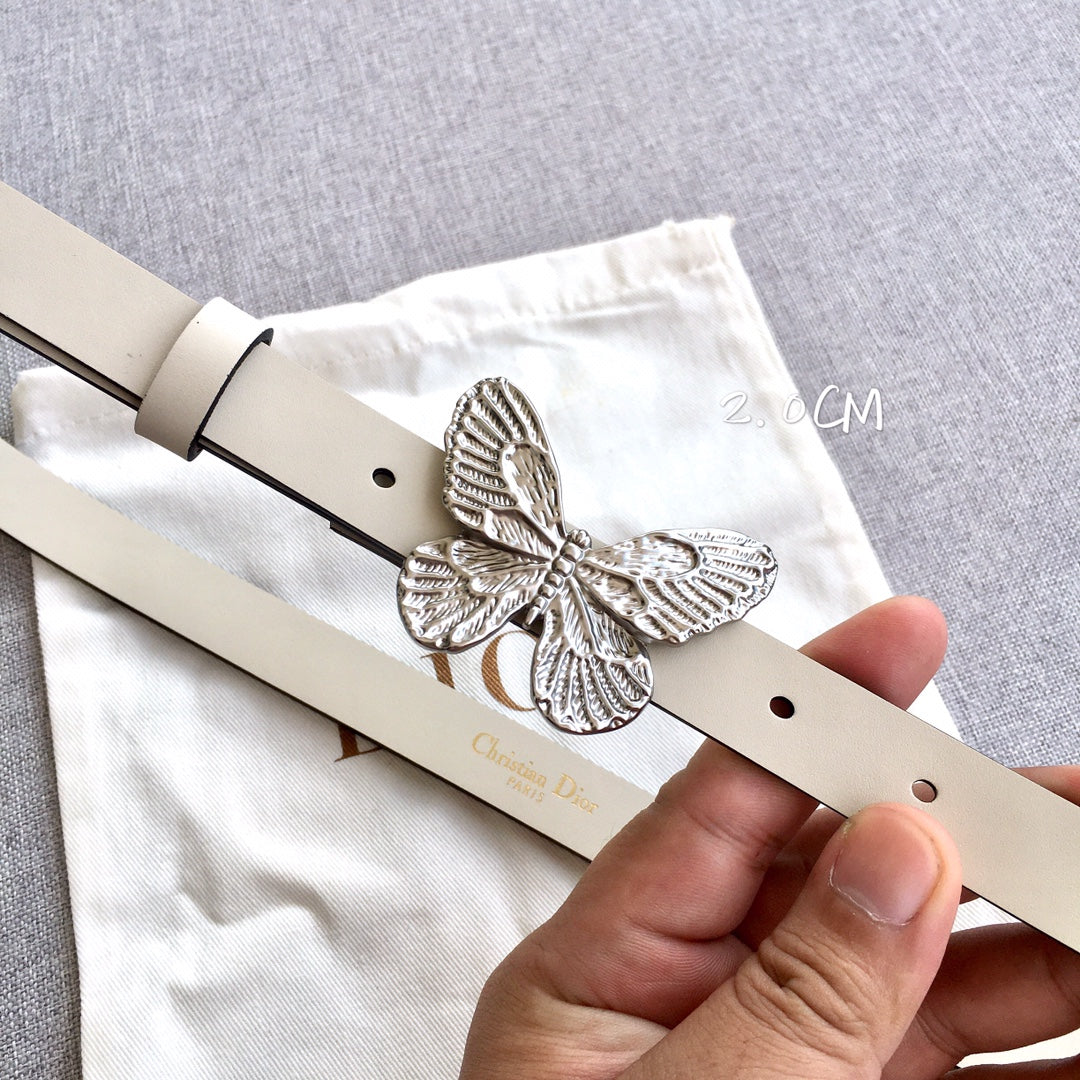 Cream leather belt with silver butterfly buckle and punched holes, close-up