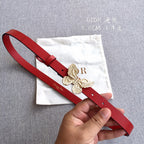 Red leather belt with gold-tone butterfly buckle, and punched adjustment holes.