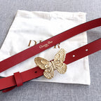 Red leather belt with gold-tone butterfly buckle, laid across a white pouch.