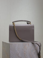 YSL bag front view with chain strap and top handle, rectangular silhouette, gray-lavender