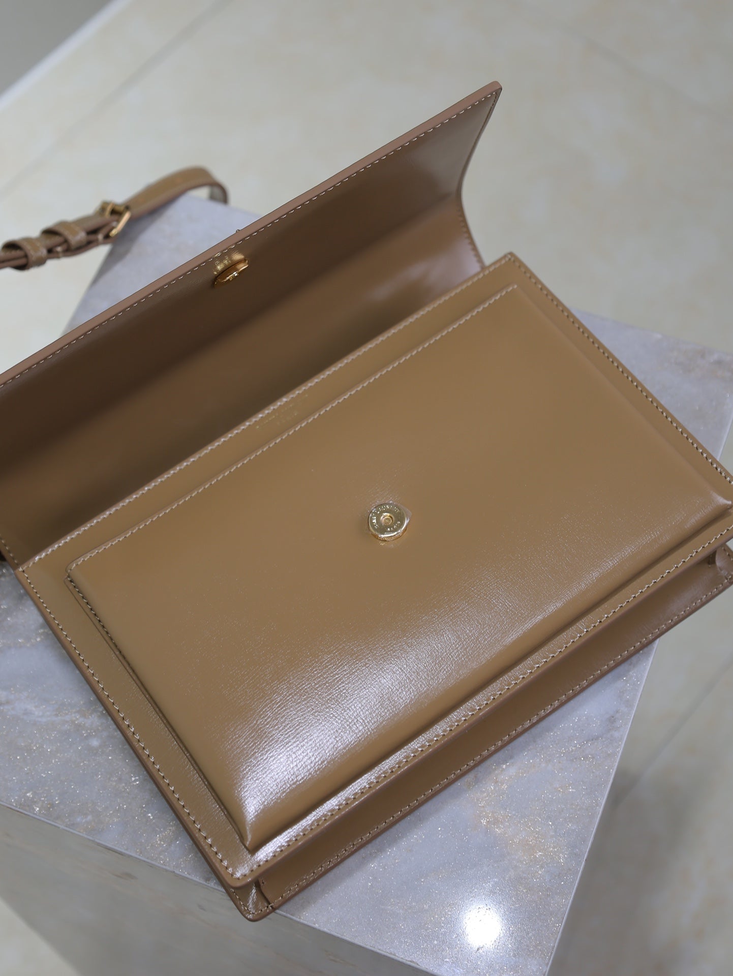 YSL tan wallet-style flap bag with gold emblem and interior pocket