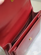 Red leather bag interior with slip pockets and gold-tone button snap.