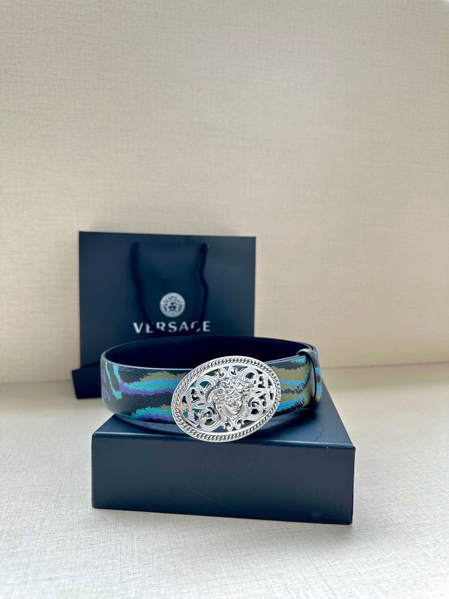 Versace belt with oval silver-tone buckle and blue-green striped patterned strap
