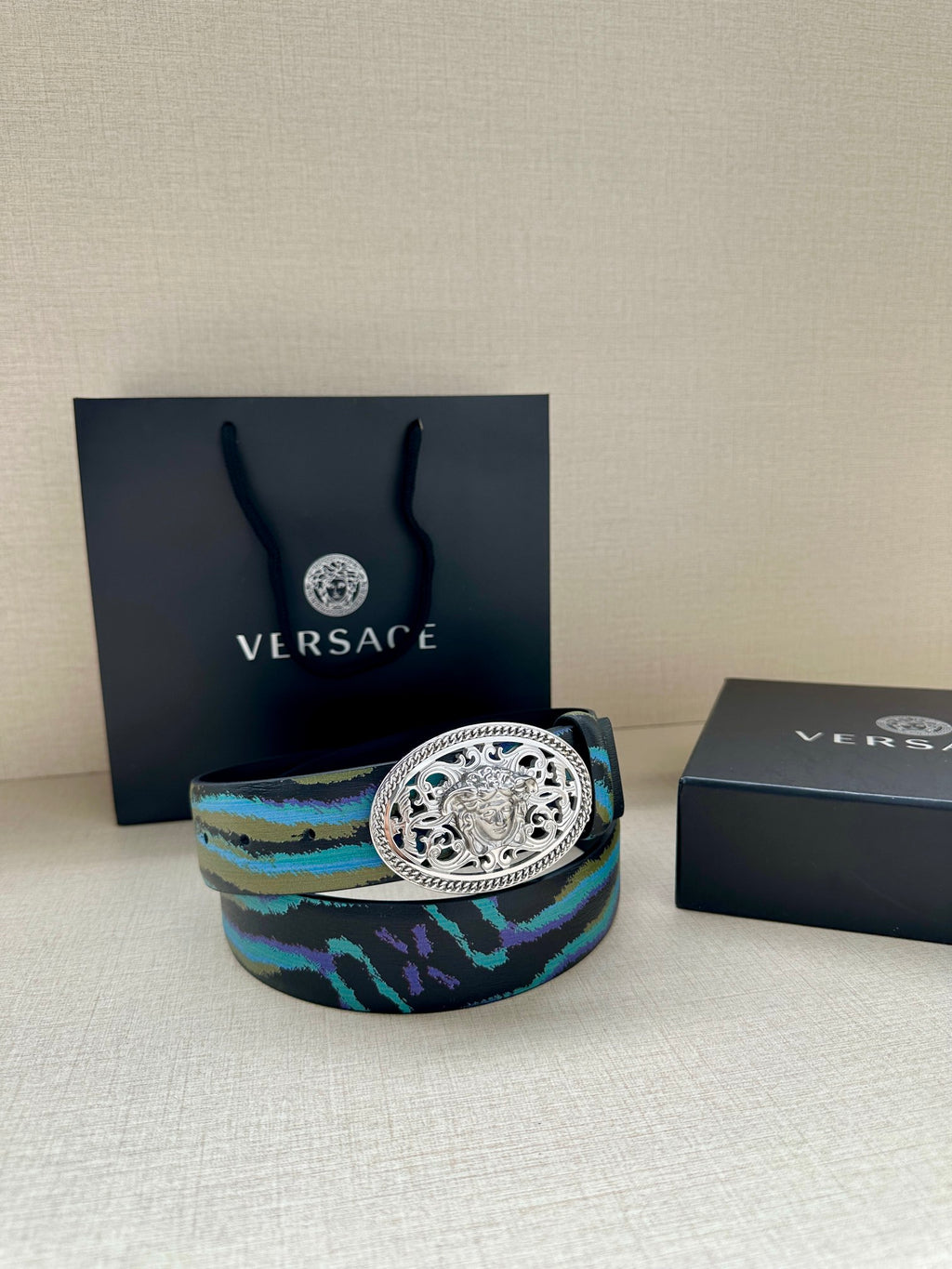 Versace belt with blue-green patterned strap and oval silver-tone buckle