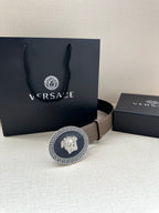 Leather belt on display with oval Greca Medusa buckle and light taupe strap