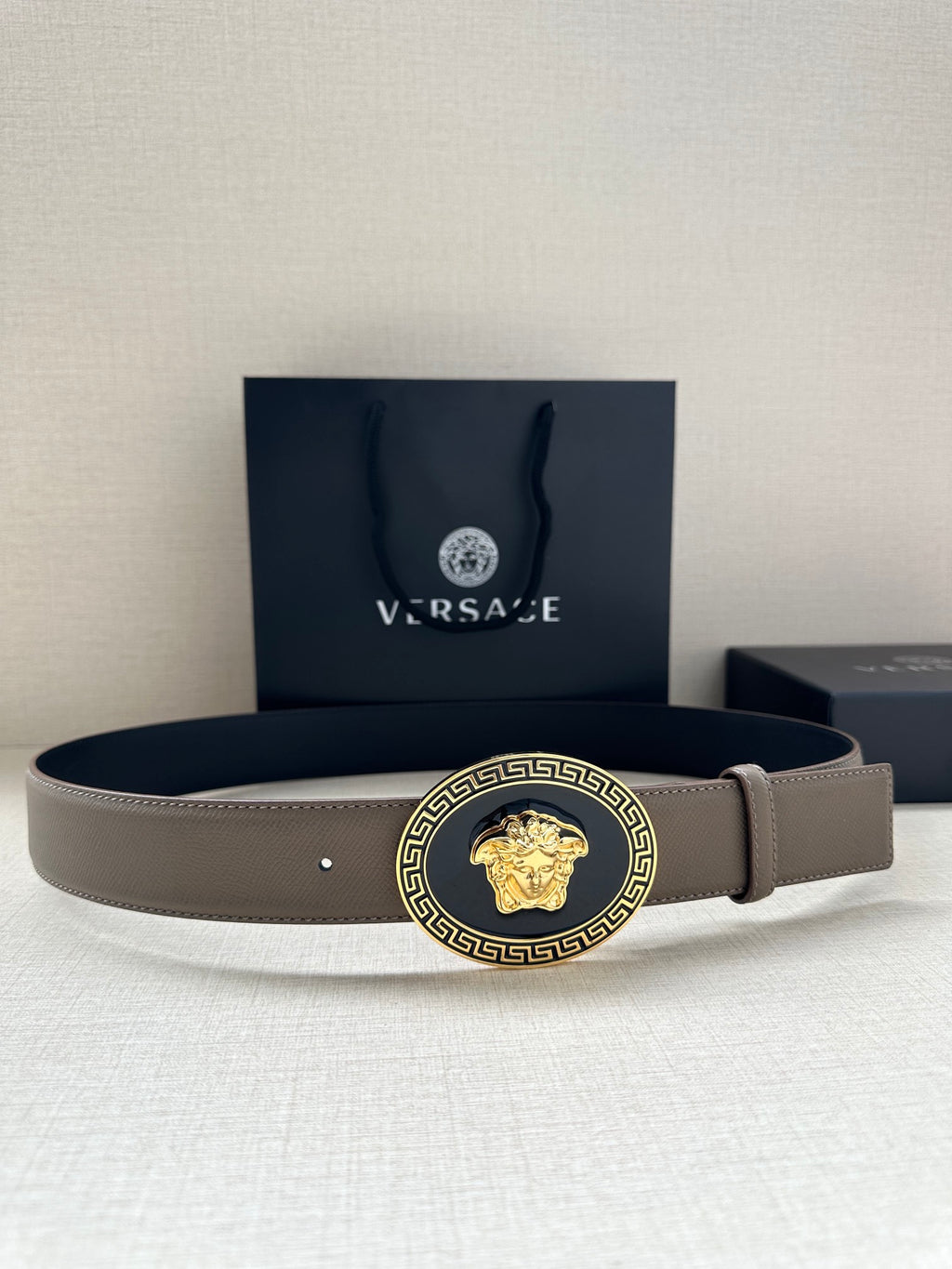 Leather belt with light taupe strap and gold-tone Medusa medallion buckle