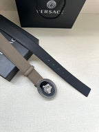 Leather belt with taupe strap and oval Greca Medusa buckle; holes along strap