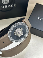 Leather belt close-up with light taupe strap and silver-tone Medusa Medallion