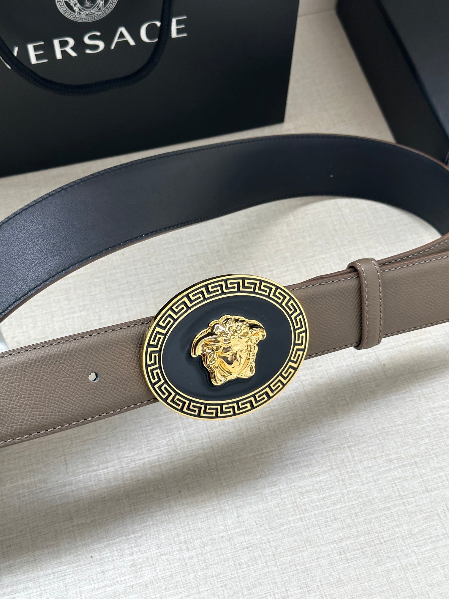 Leather belt with light taupe strap and round Greca Medusa medallion buckle