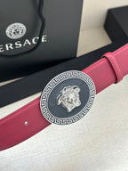 Maroon leather Versace belt viewed close-up with round gold Medusa buckle