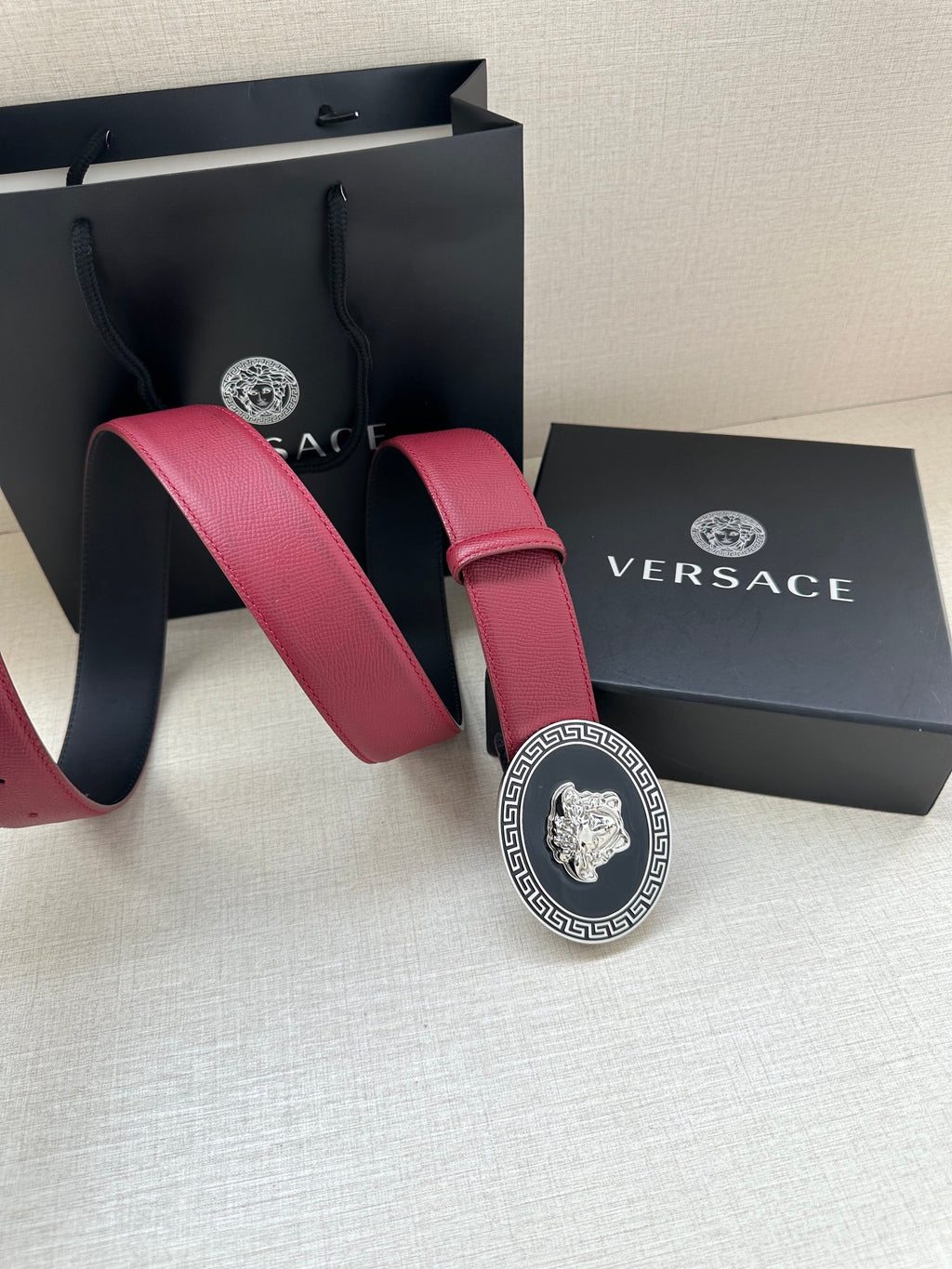 Versace maroon leather belt with round Greek key buckle and Medusa emblem