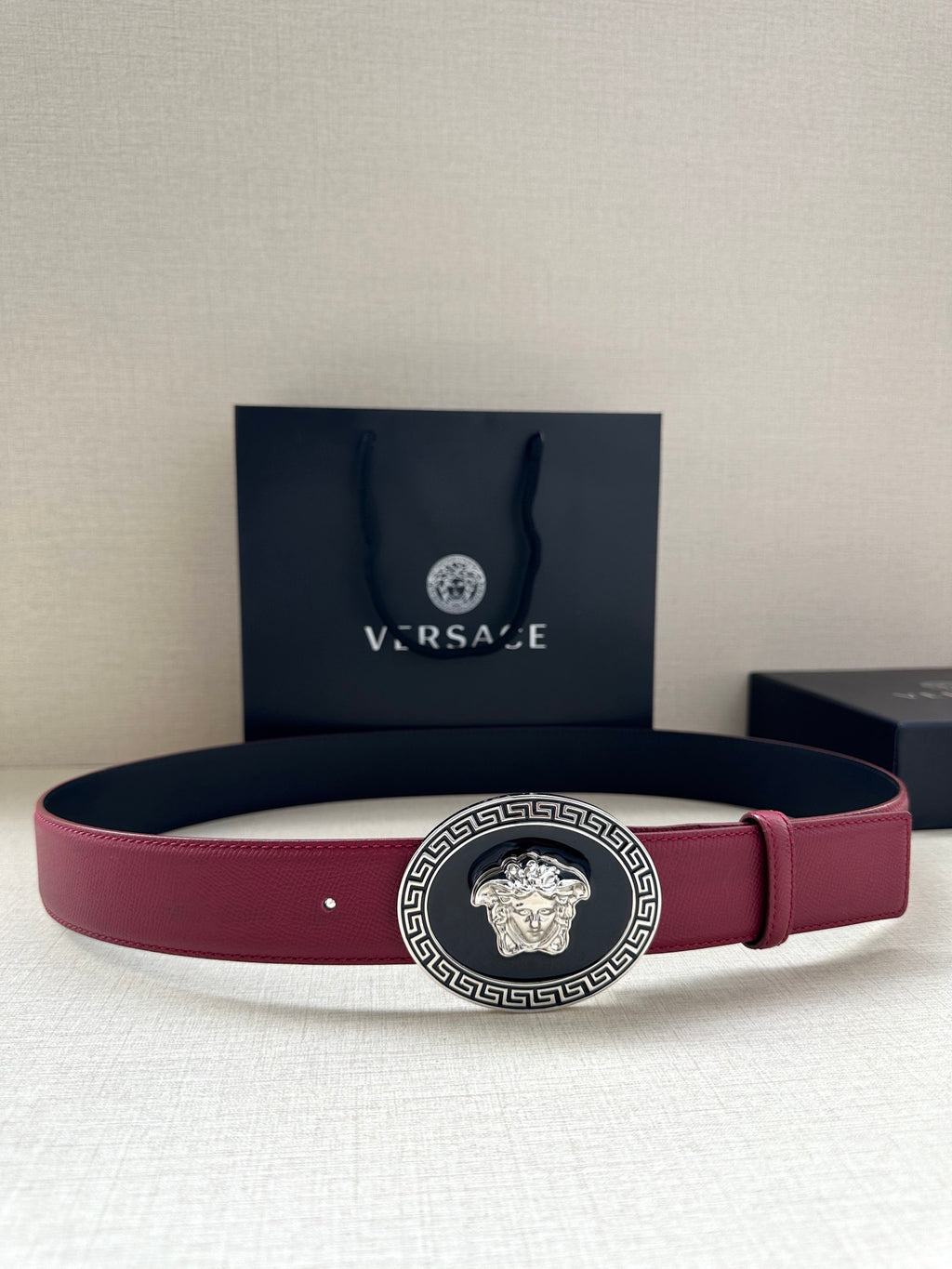 Versace belt with maroon leather strap and gold Medusa buckle with Greek key border